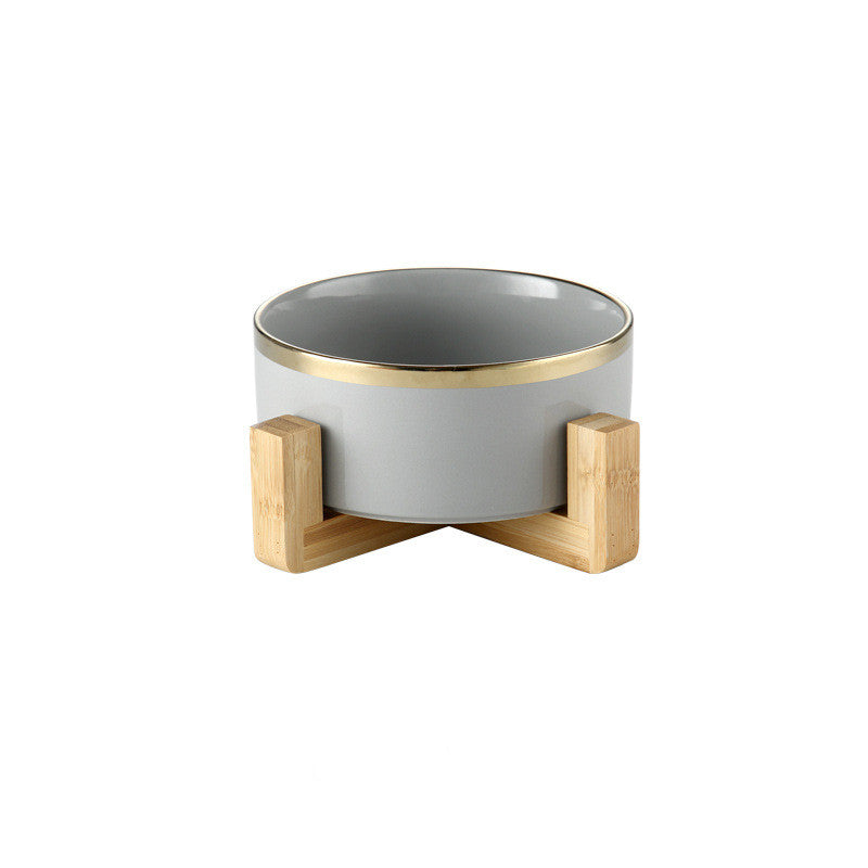 Dove grey gold-rimmed ceramic bowl on a wooden stand