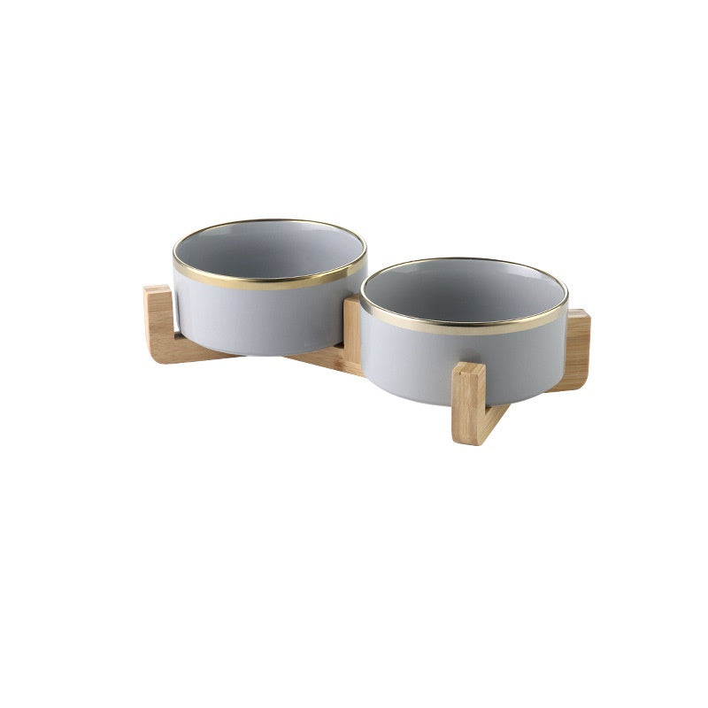 Pair of dove grey gold-rimmed ceramic bowls on wooden stands