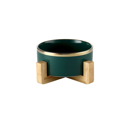 Forest green gold-rimmed ceramic bowl on a wooden stand